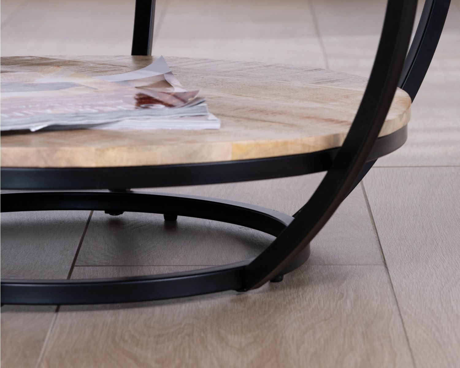 Tavolino rotondo "Loopie" con doppio piano in legno massiccio di mango e struttura in metallo nero