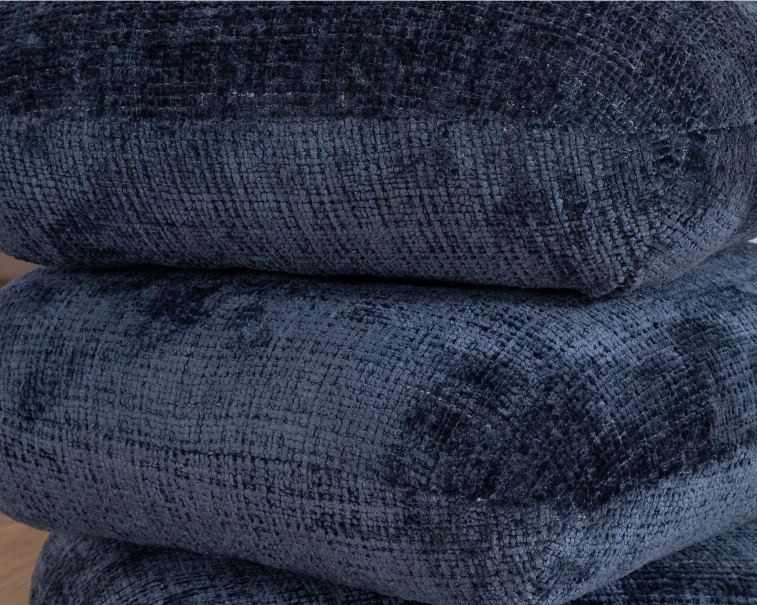 Pouf girevole moderno "Flow" in tessuto intrecciato blu notte con finitura satinata, forma organica