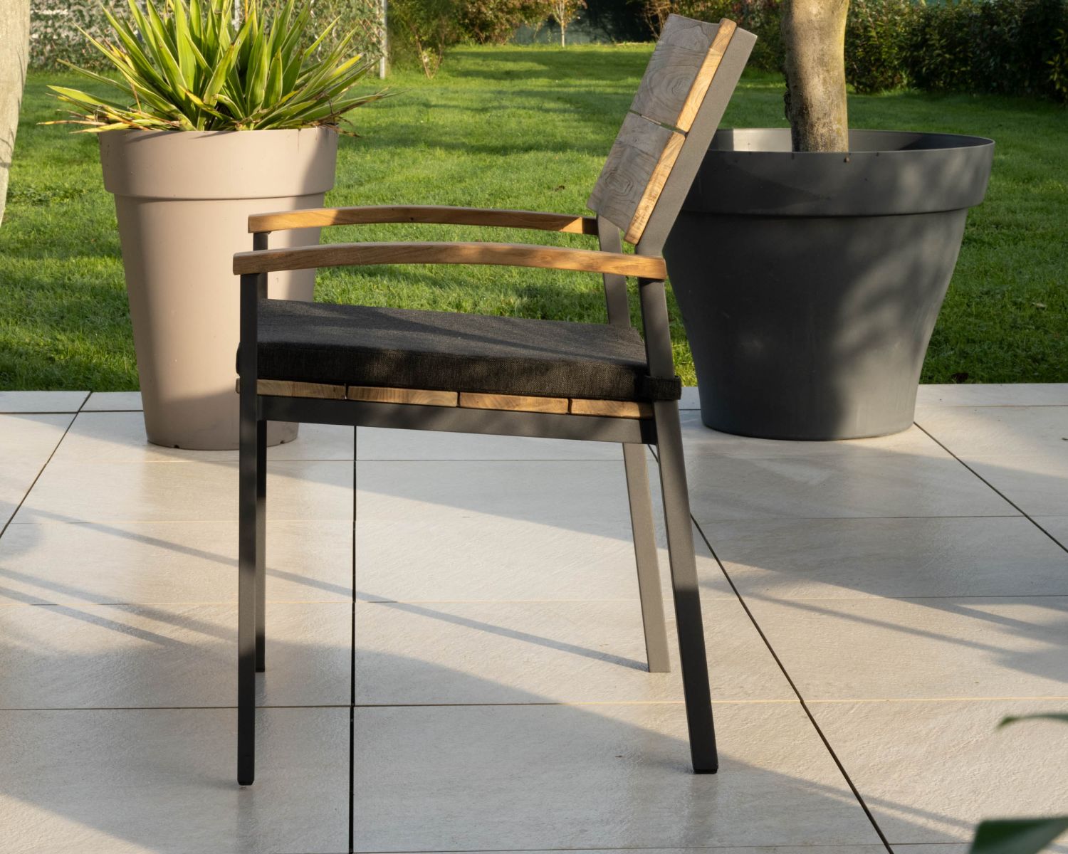 Chair'ming" è una sedia da giardino di alta gamma in teak e alluminio con cuscino in tessuto grigio