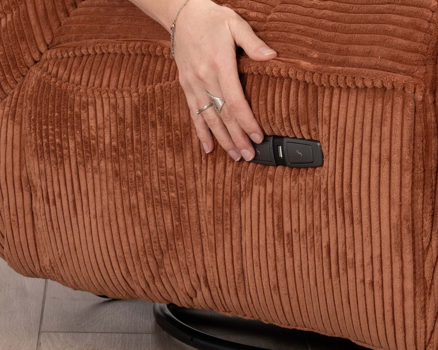 Poltrona avvolgente "Cascada" in velluto a coste color terracotta con poggiapiedi ribaltabile