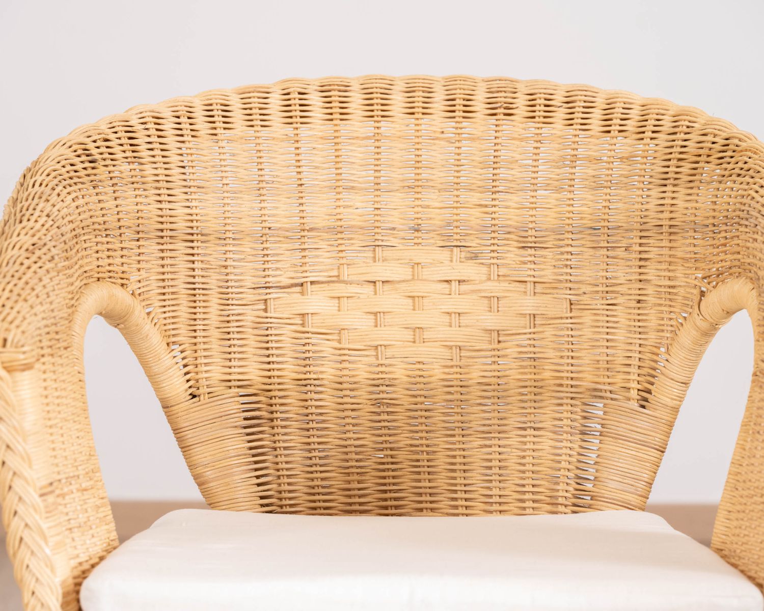 Poltroncina elegante in rattan intrecciato "Noho" con seduta in tessuto