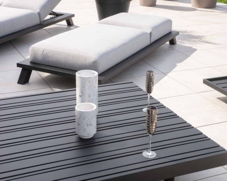 Chaise longue "Nusa Pedina" in tessuto Sunbrella grigio chiaro con struttura in alluminio nero