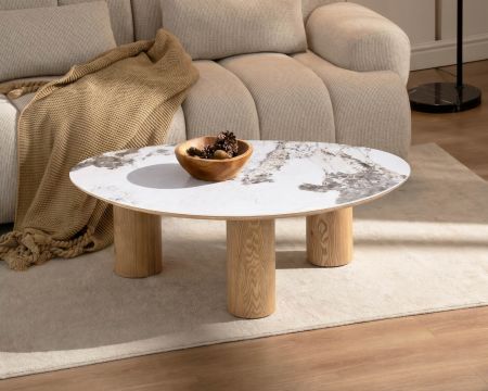 Tavolino con piano in ceramica effetto pietra naturale “Oria”, dalla forma organica e con gambe effetto rovere